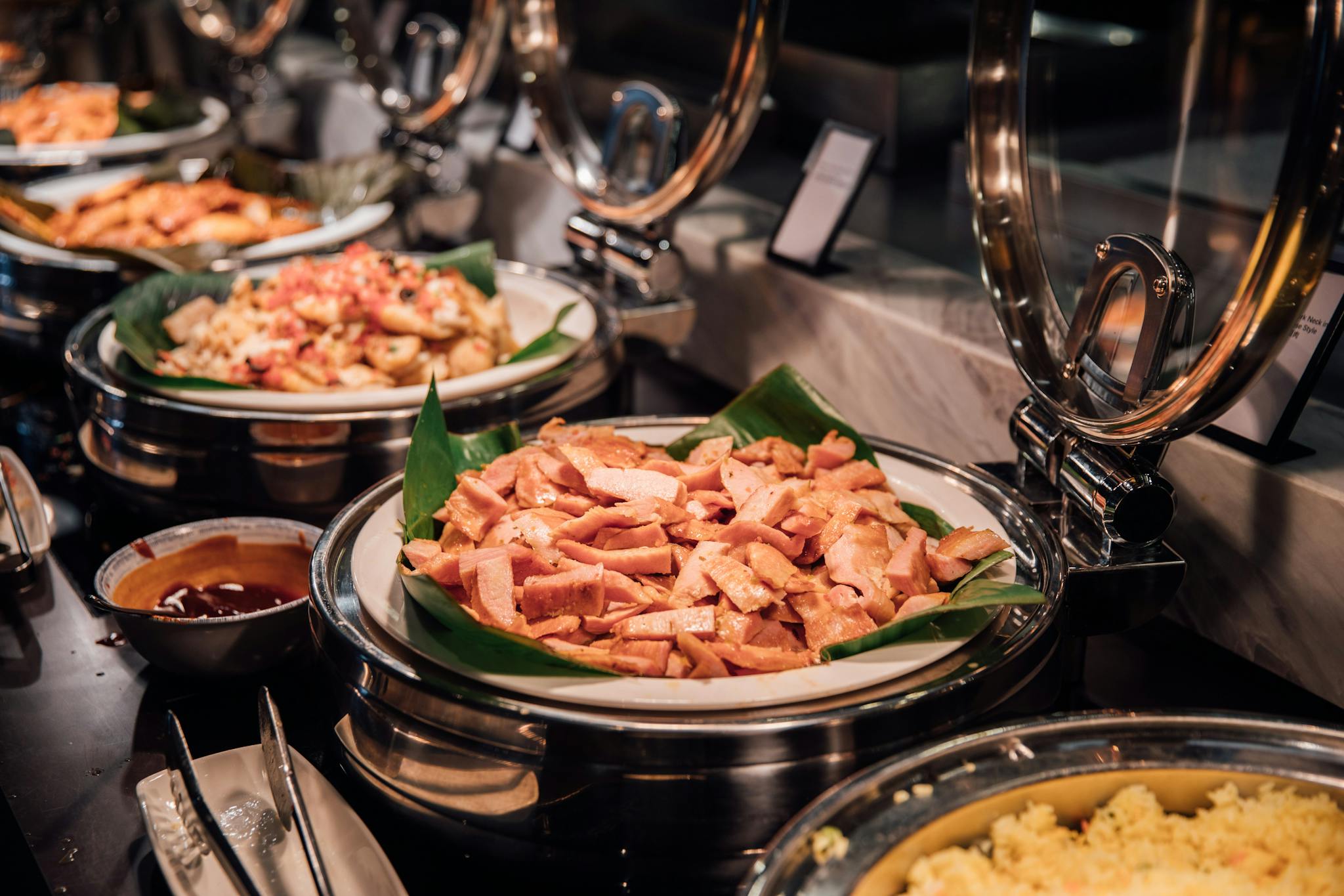 A sumptuous buffet with assorted meats and rice served in a luxurious setting.