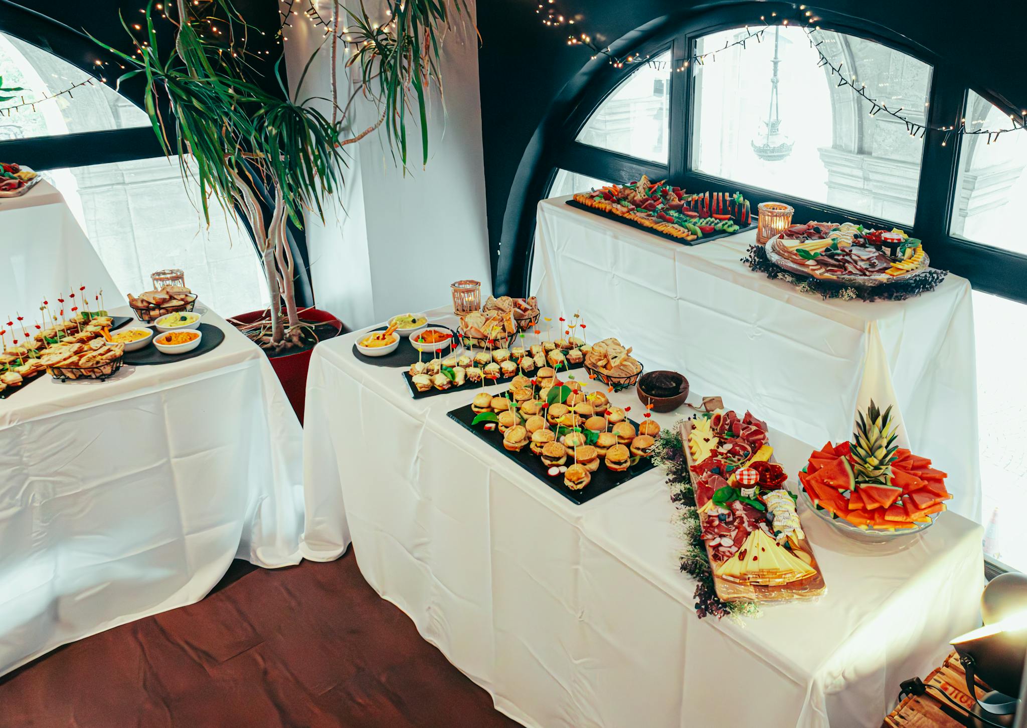 An elegant indoor buffet table featuring a variety of appetizers beautifully arranged for an event.