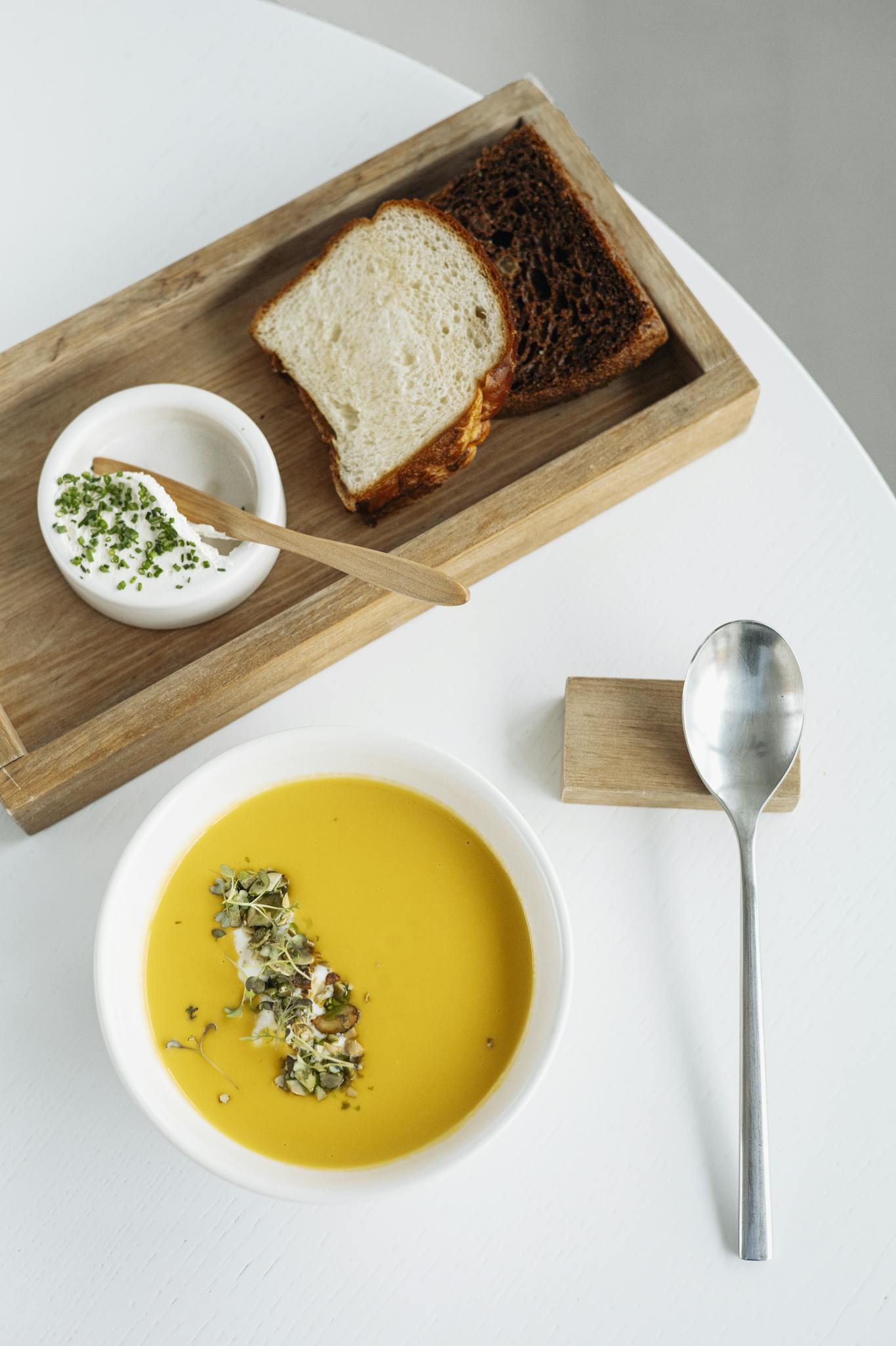 Delicious pumpkin soup served with fresh bread and a creamy dip, perfect for gourmet dining.